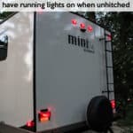 back of a RV trailer with running lights on while unplugged from the tow vehicle