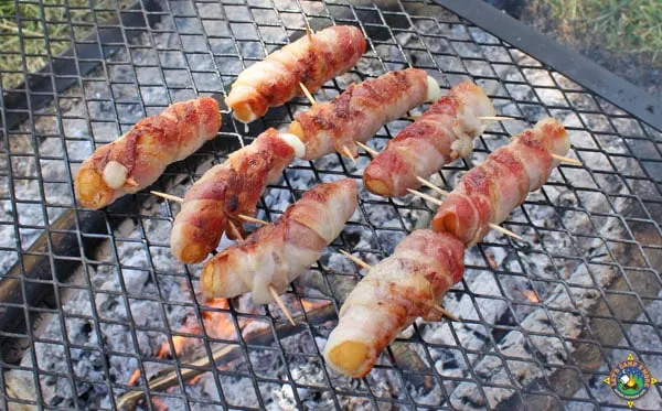 bacon mozzarella cheese sticks on a grill while camping