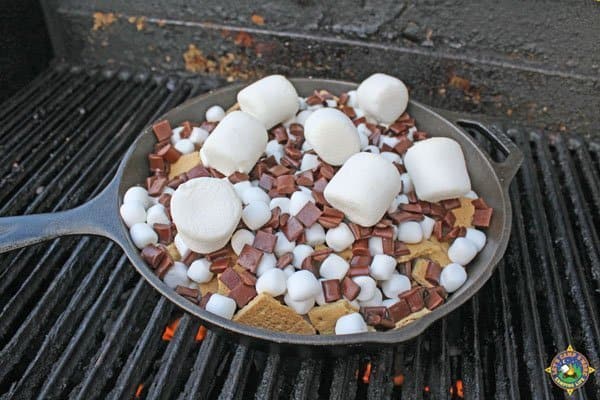 cast iron skillet of s'mores nachos on a grill