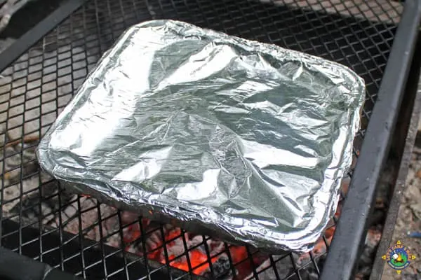foil pan cooking over a campfire