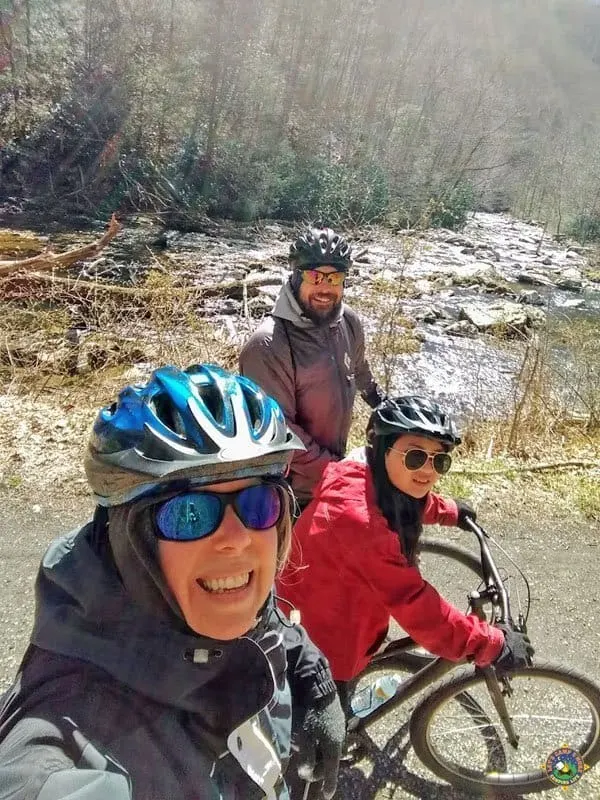 happy family on bicycles posing in front of a creek