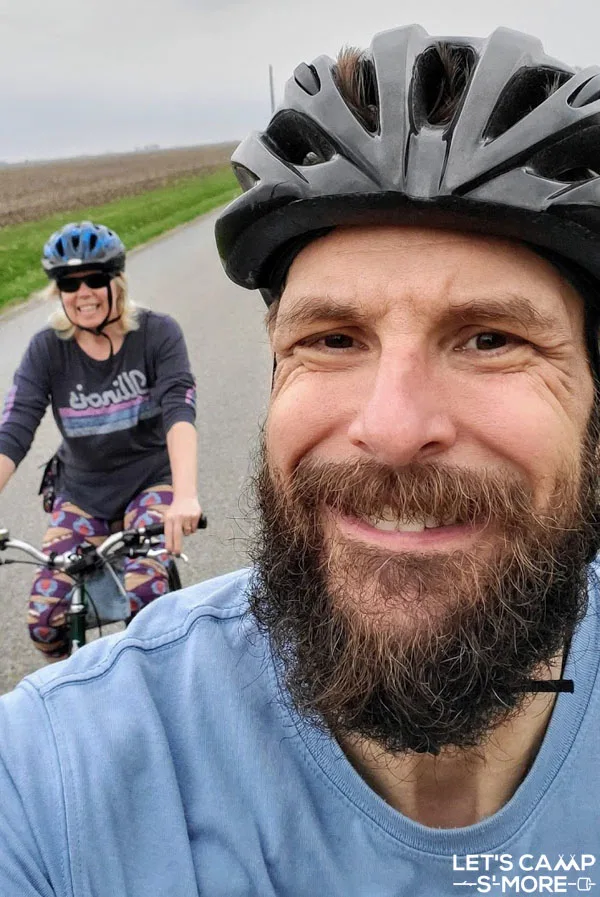 selfie of a couple riding bikes for exercise while camping