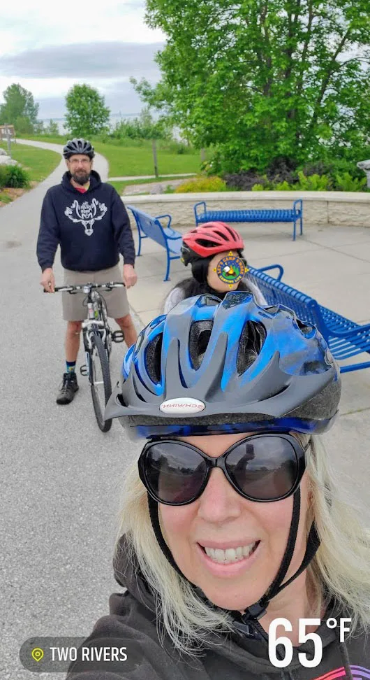 a family riding bikes along a path next to Lake Michigan in WIsconsin