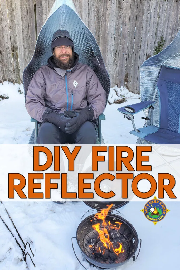 man sitting next to campfire in a camping chair with a fire reflector attached to it keeping warm