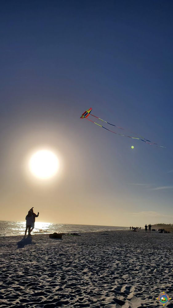 people flying a kite on the Gulf beach in Alabama