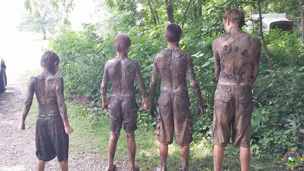 4 boys covered in mud