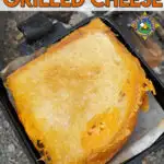 close up of a campfire grilled cheese sandwich in a pie iron