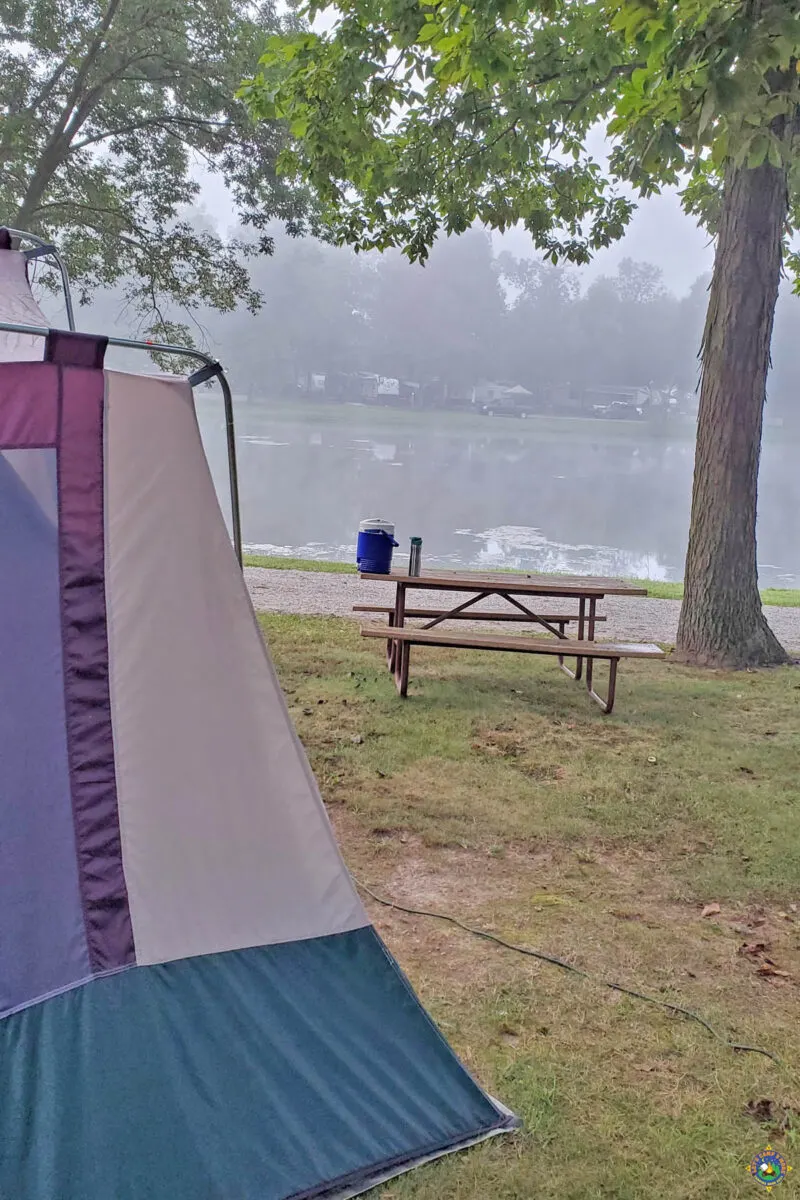 a tent next to a lake in a campground