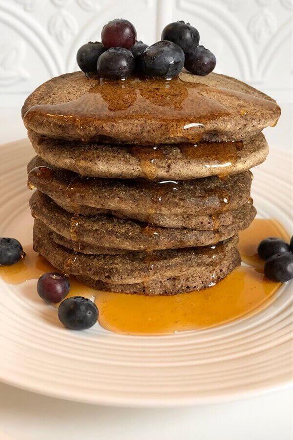 stack of buckwheat pancakes with berries and syrup
