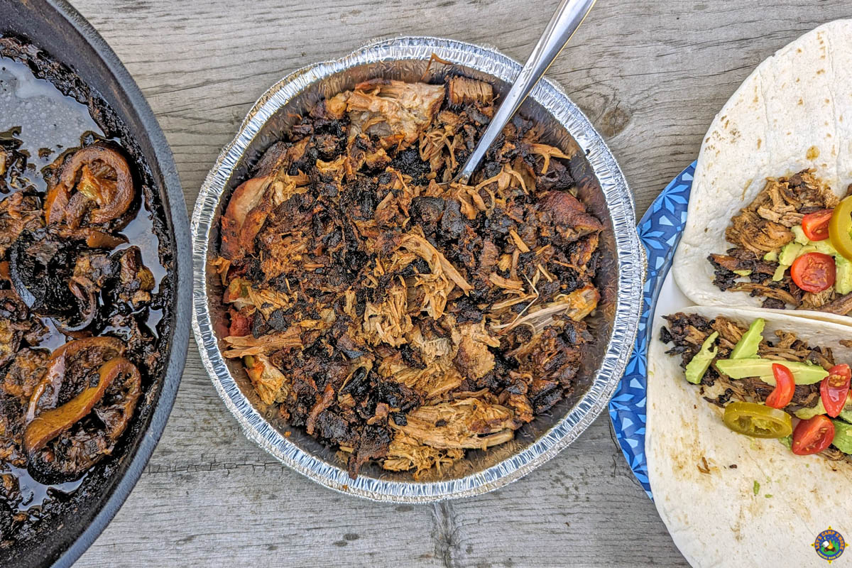 Pork Carnitas in a Dutch Oven with pulled pork in a pan and tacos