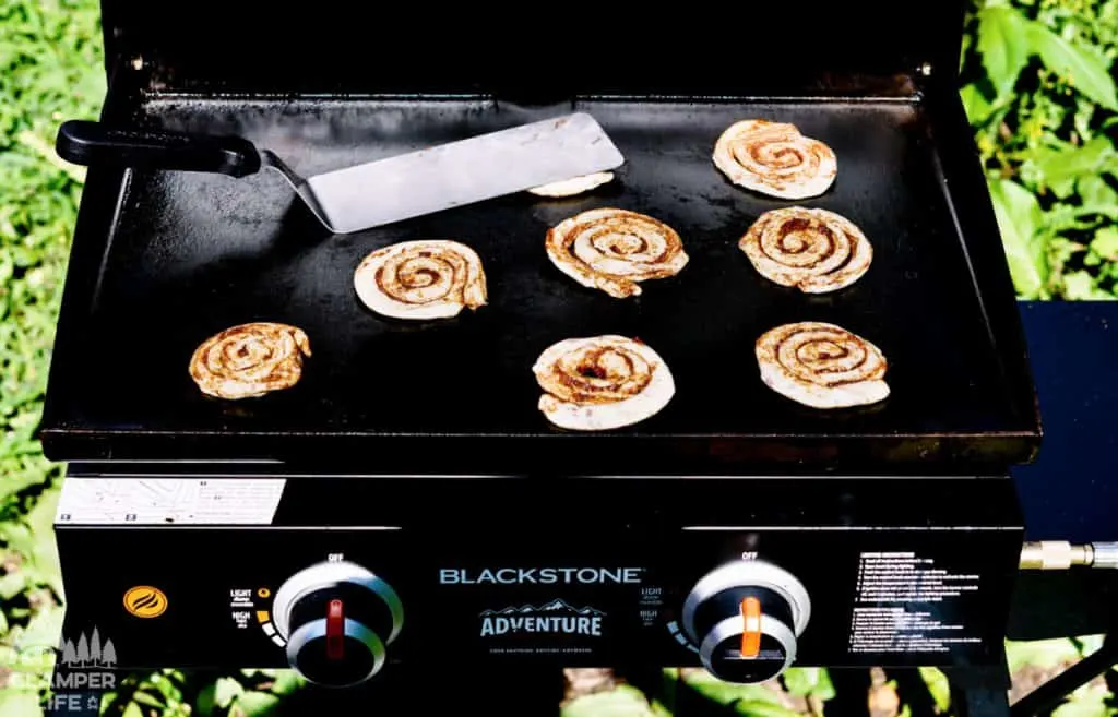 cinnamon rolls being cooked on a griddle