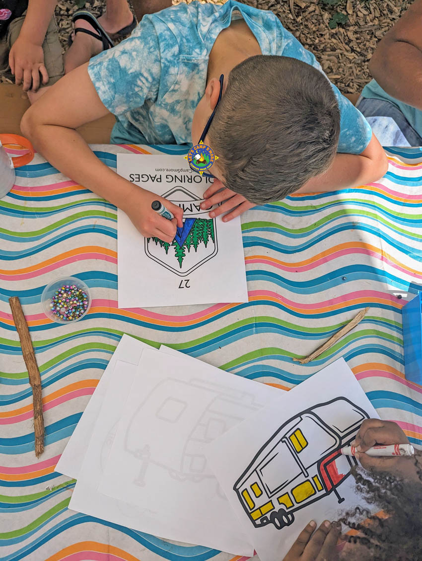 2 boys adding color to camping coloring pages