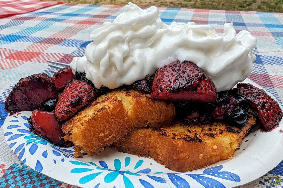 a serving of Grilled Lemon Pound Cake with Berries with cream on top